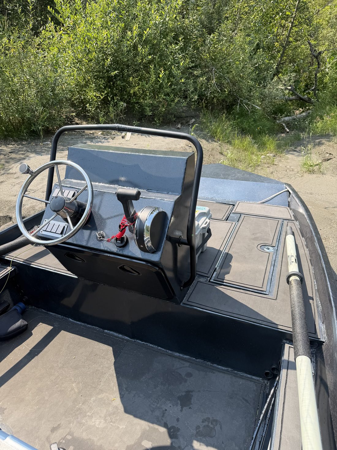 Helm console with a stainless steering wheel, switch panels and throttle